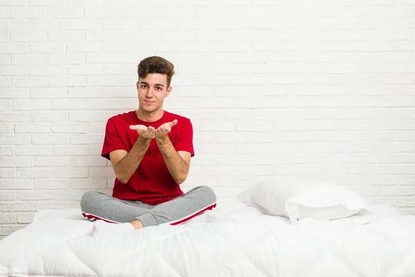Genç Genç Öğrenci Adam Yatakta Avuç Içi Ile Bir Şey — Stok fotoğraf