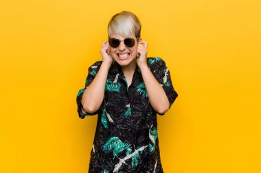 Genç kıvrımlı kadın elleri ile kulakları kapsayan bir yaz bakmak giyiyor.