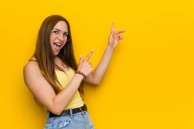 Genç kızıl saçlı zencefil kadın bir kopya alanı için ön parmakları ile işaret pervasız, heyecan ve arzu ifade.