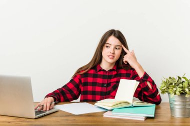 Genç genç işaret parmağı ile bir hayal kırıklığı jest gösteren ödevleri yapıyor rutin geri dönüyor.