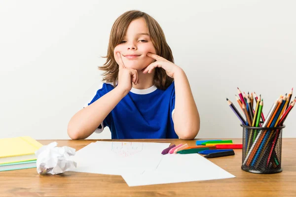 小さな男の子の絵を描き 彼の机の上で宿題を行うことは 2つのオプションの間で疑問を持っています — ストック写真