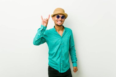 Genç İspanyol adam bir devrim kavramı olarak boynuzları jest gösteren bir yazlık giysiler giyiyor.