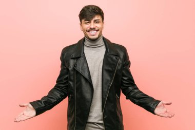 Hoş bir ifade gösteren bir deri ceket giyen genç İspanyol adam.