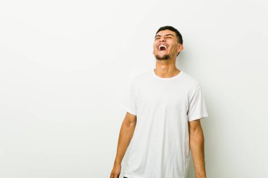 Genç İspanyol adam rahat ve mutlu gülerek, boyun diş gösteren gerilmiş.