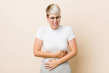 Beyaz gömlek hasta giyen genç otantik doğal kadın, mide ağrısı muzdarip, ağrılı hastalık kavramı.