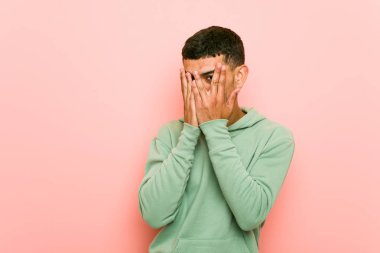 Genç İspanyol spor adam korkmuş ve sinirli parmakları ile göz kırpma.