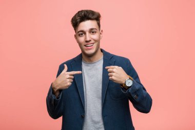 Genç iş doğal adam kendini işaret şaşırttı, geniş gülümseyerek.