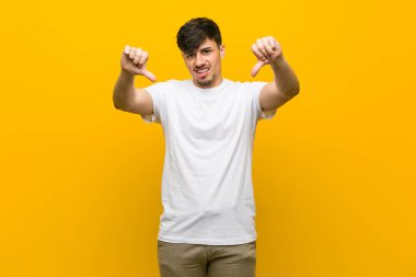 Genç İspanyol rahat adam başparmak aşağı gösteren ve sevmediğimi ifade.