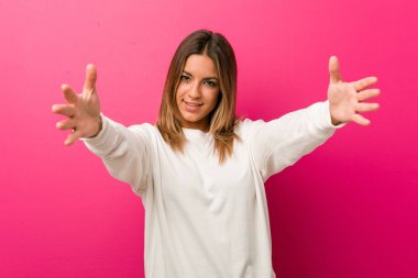 Bir duvara karşı genç otantik karizmatik gerçek insanlar kadın kameraya sarılmak vererek emin hissediyor.