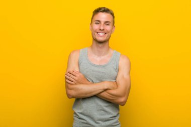 Kendini güvende hisseden genç kafkas spor adamı, kararlılıkla kolları keserek.