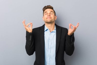 Genç yakışıklı beyaz adam zor iş gününden sonra rahatlatır, o yoga yapıyor.