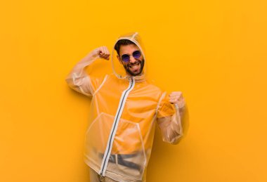 Yağmurluk giyen genç adam teslim olmuyor.