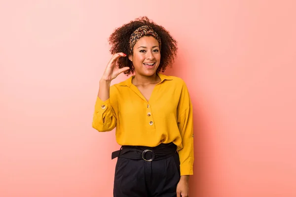 年轻的非洲裔美国妇女 在粉红色的背景持有一些小食指 微笑和自信的东西 — 图库照片