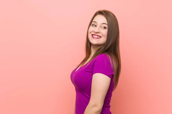 Joven Mujer Hispana Contra Una Pared Rosa Mira Lado Sonriente — Foto de Stock