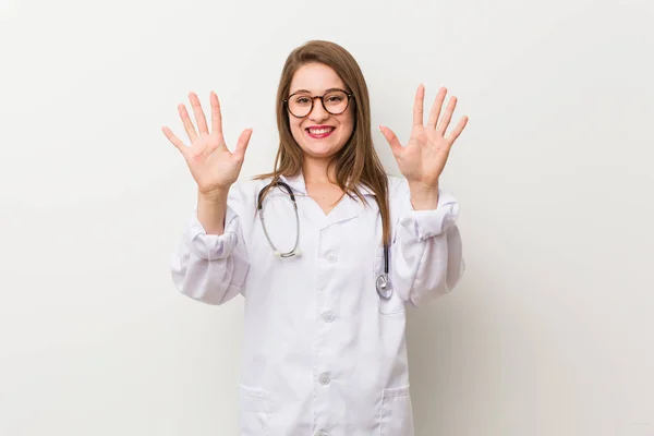 Jonge Dokter Vrouw Tegen Een Witte Muur Toont Nummer Tien — Stockfoto