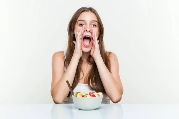 Giovane Donna Caucasica Mangiare Frutta Ciotola Gridando Entusiasta Fronte — Foto Stock