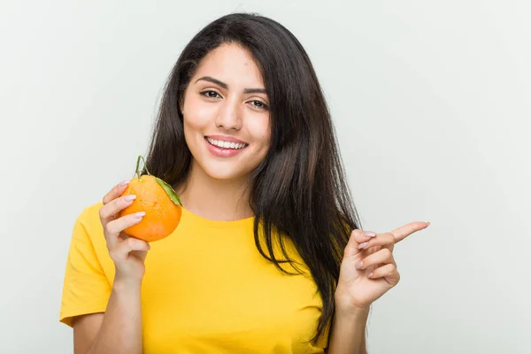 Junge Hispanische Frau Hält Ein Orangefarbenes Lächeln Und Zeigt Fröhlich — Stockfoto