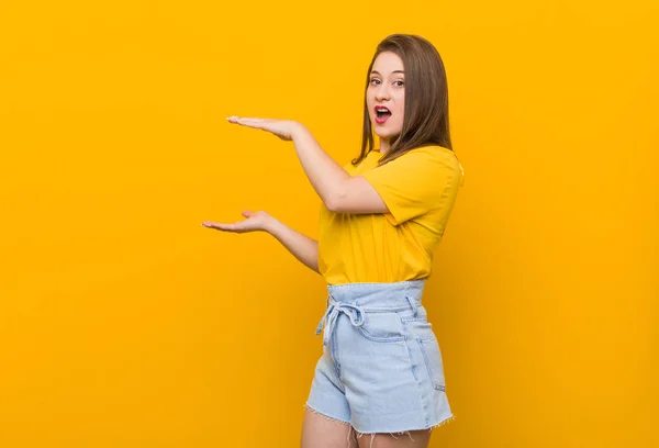 Jovem Adolescente Vestindo Uma Camisa Amarela Chocado Espantado Segurando Espaço — Fotografia de Stock