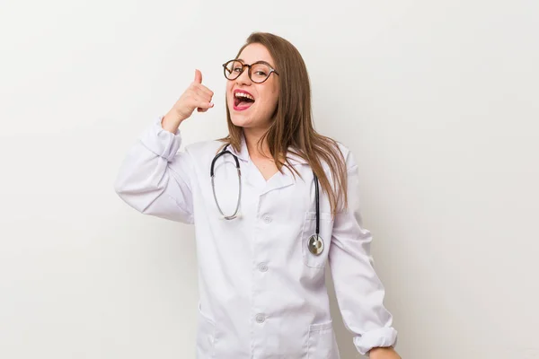 Junge Ärztin Vor Einer Weißen Wand Die Eine Handygeste Mit — Stockfoto