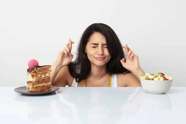 Young Hispanic Woman Choosing Cake Fruit Crossing Fingers Having Luck — Stock Photo, Image