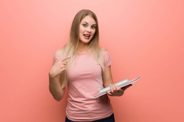 Genç güzel rus kız şaşırttı, başarılı ve müreffeh hissediyor. Elinde kitap var..