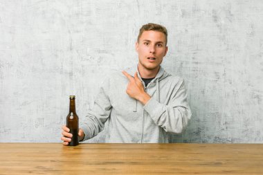 Genç adam yan gösteren bir masada birbira içme