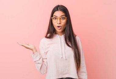 Rahat bir spor giyen genç güzel Arap kadın palmiye üzerinde kopya alanı tutarak etkilendim bakmak.