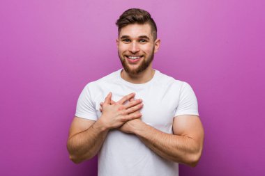 Genç yakışıklı beyaz adam dostça bir ifade, göğüs avuç içi basarak vardır. Aşk kavramı.