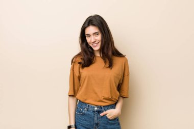 Bej arka plan mutlu, gülümseyen ve neşeli karşı Genç esmer kadın.