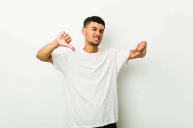 Genç İspanyol adam başparmak aşağı gösteren ve sevmediğimi ifade.