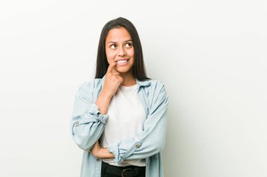 Genç İspanyol kadın bir kopya alanı bakarak bir şey hakkında düşünme rahat.