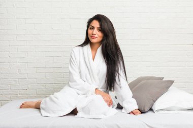 Yatakta kahvaltı eden genç İspanyol kadın