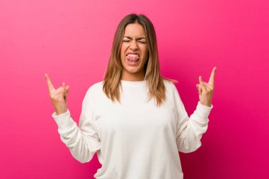 Parmakları ile kaya jest gösteren bir duvara karşı Genç otantik karizmatik gerçek insanlar kadın