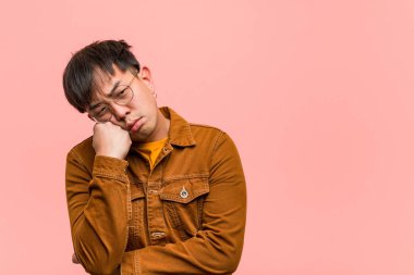 Ceket giyen genç çinli adam bir şey düşünüyor, yan bakıyor