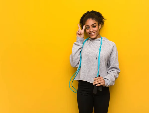 Young fitness black woman fun and happy doing a gesture of victory. Holding a jump rope.