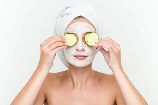 年轻的白种妇女享受与黄瓜的面部面具治疗 — 图库照片