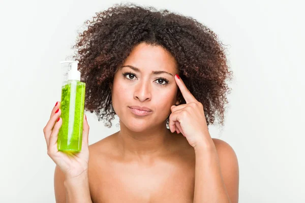 Joven Mujer Afroamericana Sosteniendo Botella Aloe Vera Señalando Sien Con —  Fotos de Stock