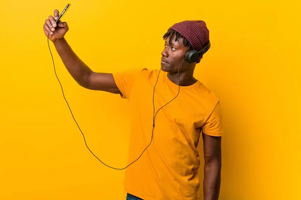 Jovem Africano Contra Fundo Amarelo Usando Chapéu Ouvindo Música Com — Fotografia de Stock