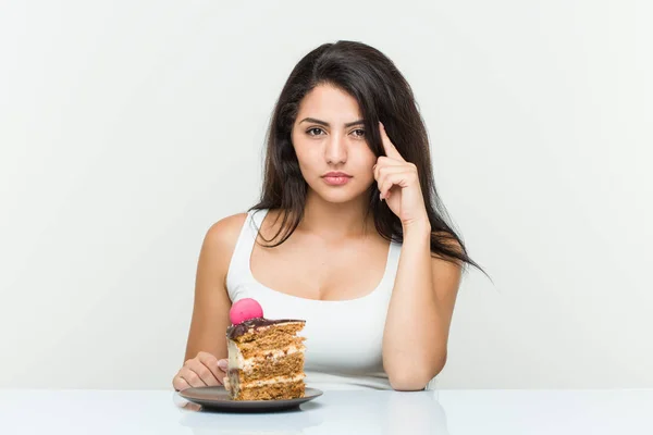 Young Hispanic Woman Eating Cake Pointing His Temple Finger Thinking — Stock Photo, Image