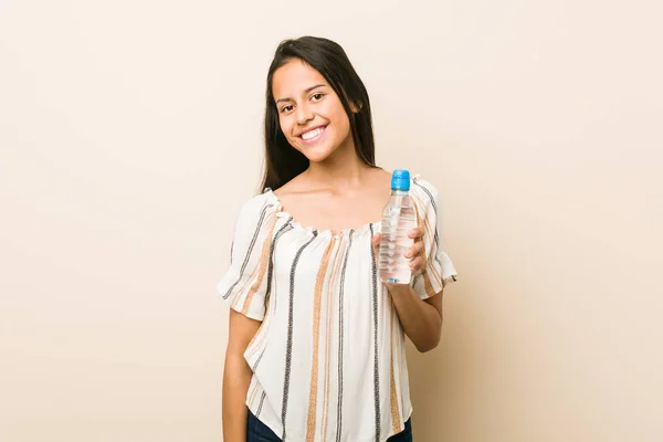 Junge Hispanische Frau Hält Eine Flasche Wasser Glücklich Lächelnd Und — Stockfoto