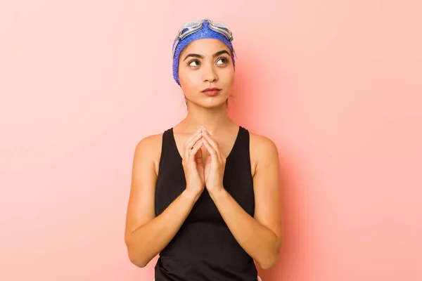 Young arab swimmer woman isolated making up plan in mind, setting up an idea.