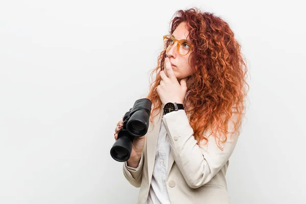 Junge Kaukasische Geschäftsfrau Mit Fernglas Und Zweifelndem Und Skeptischem Gesichtsausdruck — Stockfoto