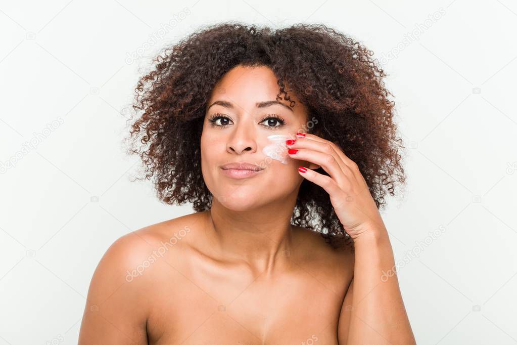 Close up of a young african american woman applying a moisturizing cream