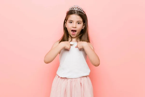 Маленька Дівчинка Принцесі Виглядає Здивованою Вказуючи Пальцем Посміхаючись Широко — стокове фото