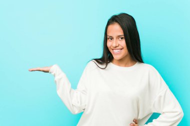 Genç güzel İspanyol kadın bir avuç üzerinde bir kopya alanı gösteren ve bel başka bir el tutarak.