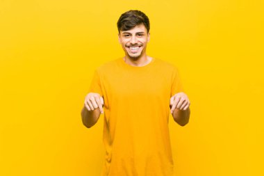 Genç İspanyol rahat adam parmakları ile aşağı işaret, olumlu duygu.