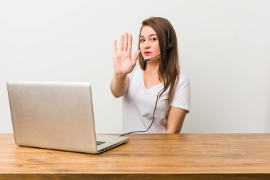 Genç telemarketer kadın uzanmış el ile dur işareti gösteren ayakta, sizi engelleyen.