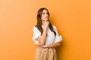 Şüpheli ve şüpheci bir ifadeyle yan bakan beyaz bir kadın..