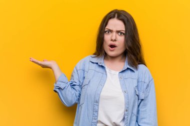 Genç kıvrımlı artı boyutu kadın palmiye üzerinde kopya alanı tutarak etkilendim.