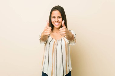 Başparmak ups ile Genç İspanyol kadın, bir şey hakkında tezahürat, destek ve saygı kavramı.